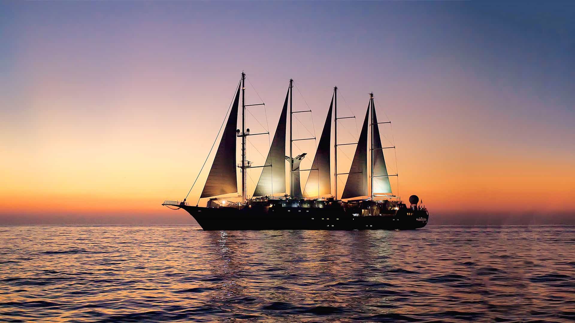 Windstar's Wind Star sailing yacht sailing at sunset.